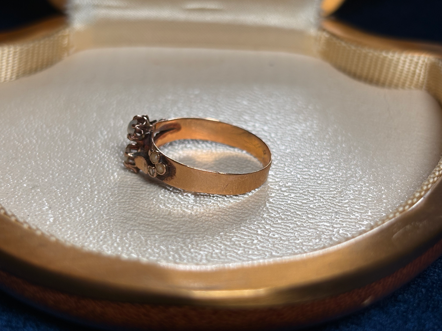 Gold ring set with pearls on a textured surface