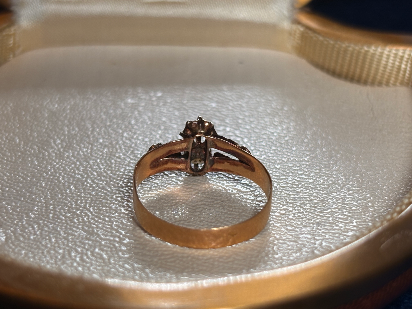 Gold ring with a pearl on a textured surface